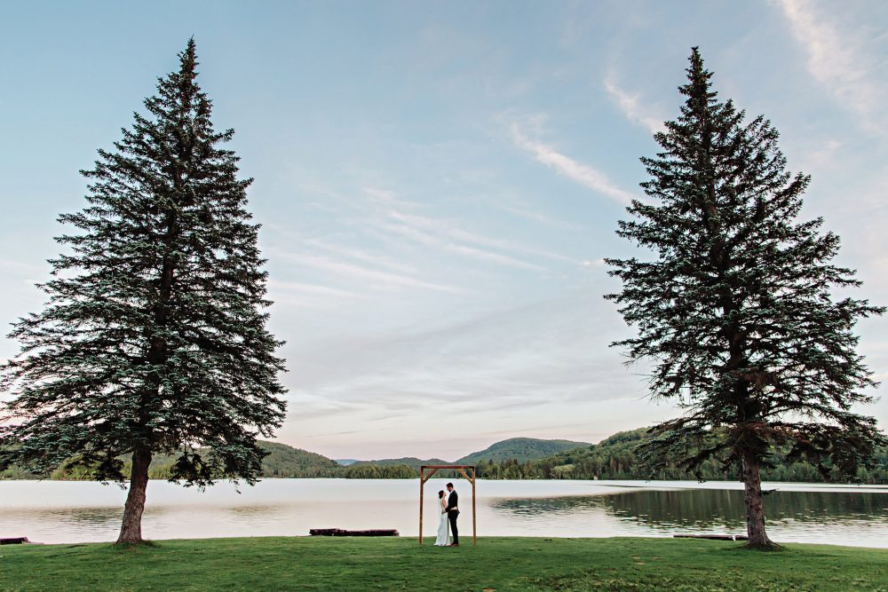 symmetrical wedding portrait next to a lake