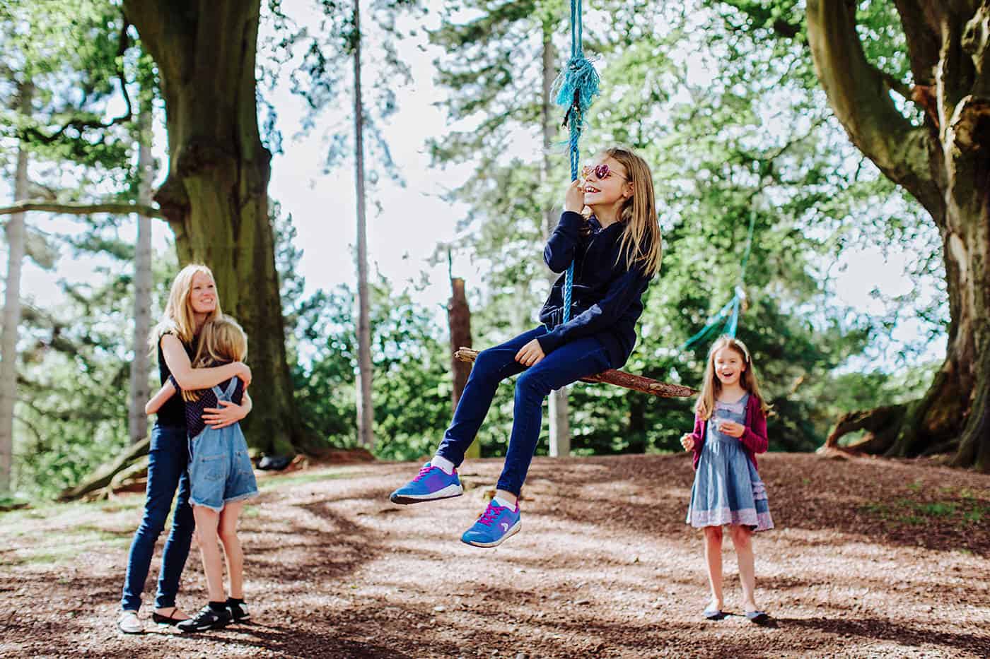 Candid family portrait taken in the woods with a rope swing
