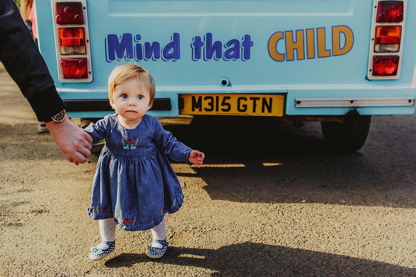 Toddler standing behind ice cream truck with Mind That Child slogan