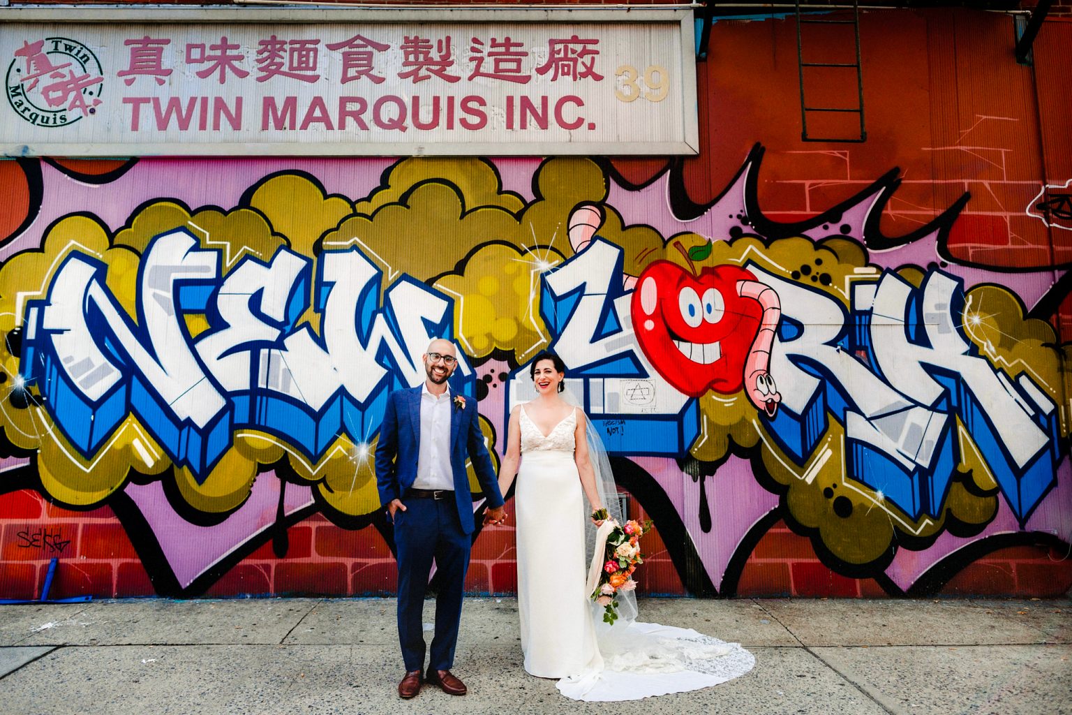 bride and groom in front of New York graffiti