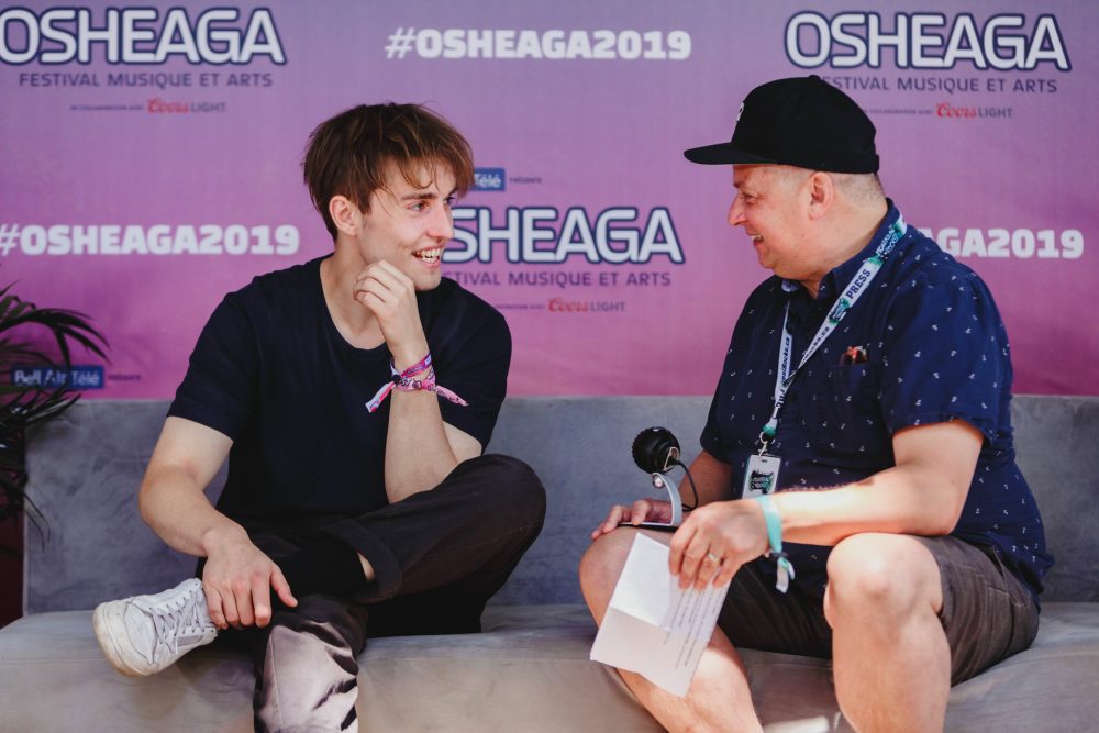 A man interviewing a man on a sofa.