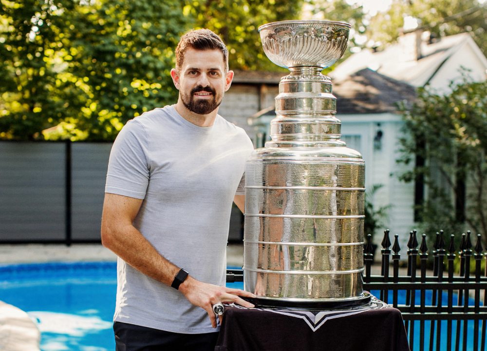 A man standing proudly next to his trophy.