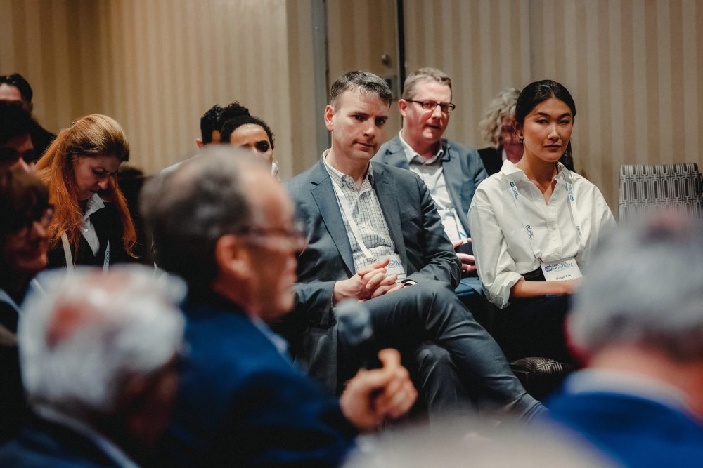 A man listening to a speak in the crowd.
