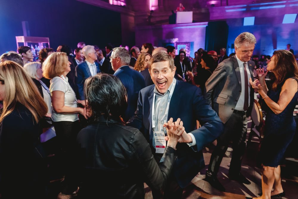 A man dancing with his parter at an event.