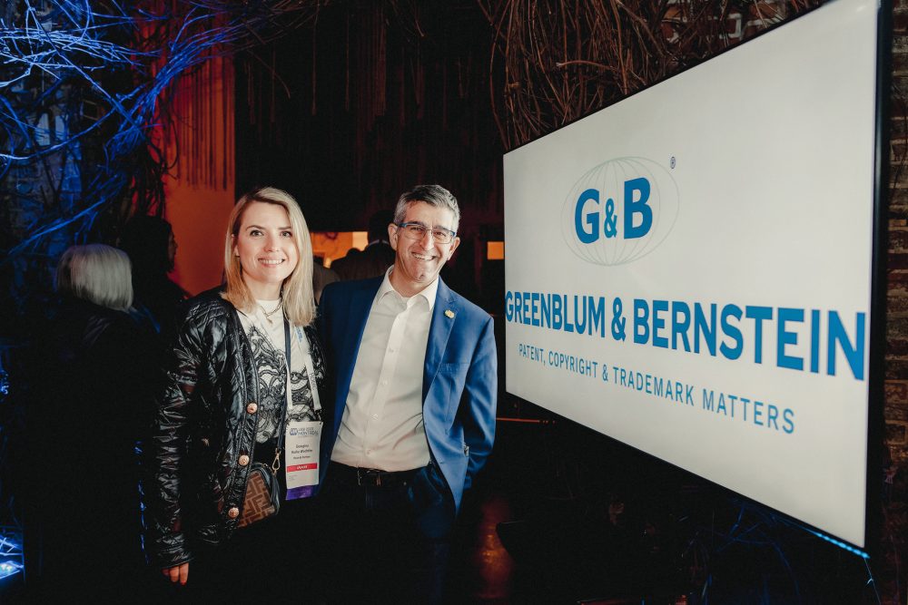 Event goers stand in front of an advertising banner.