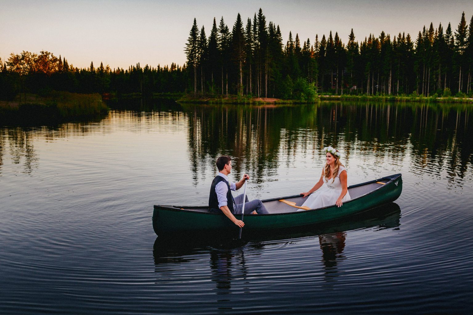 bride and groom in rowboat on lake at a wedding in Quebec