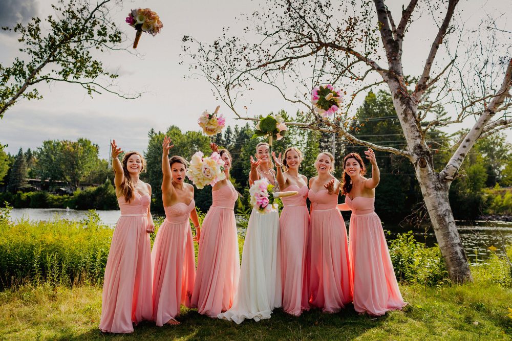 bride and bridesmaids throwing bouquets towards the camera