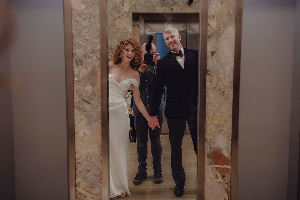Wedding photographer and couple reflected in a mirror