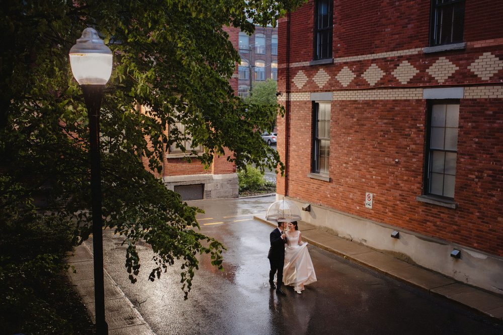 A couple walk in the rain with an umbrella at Entrepots Dominion