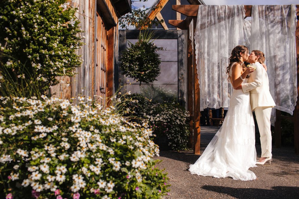 Two brides kiss outside their wedding venue in Quebec