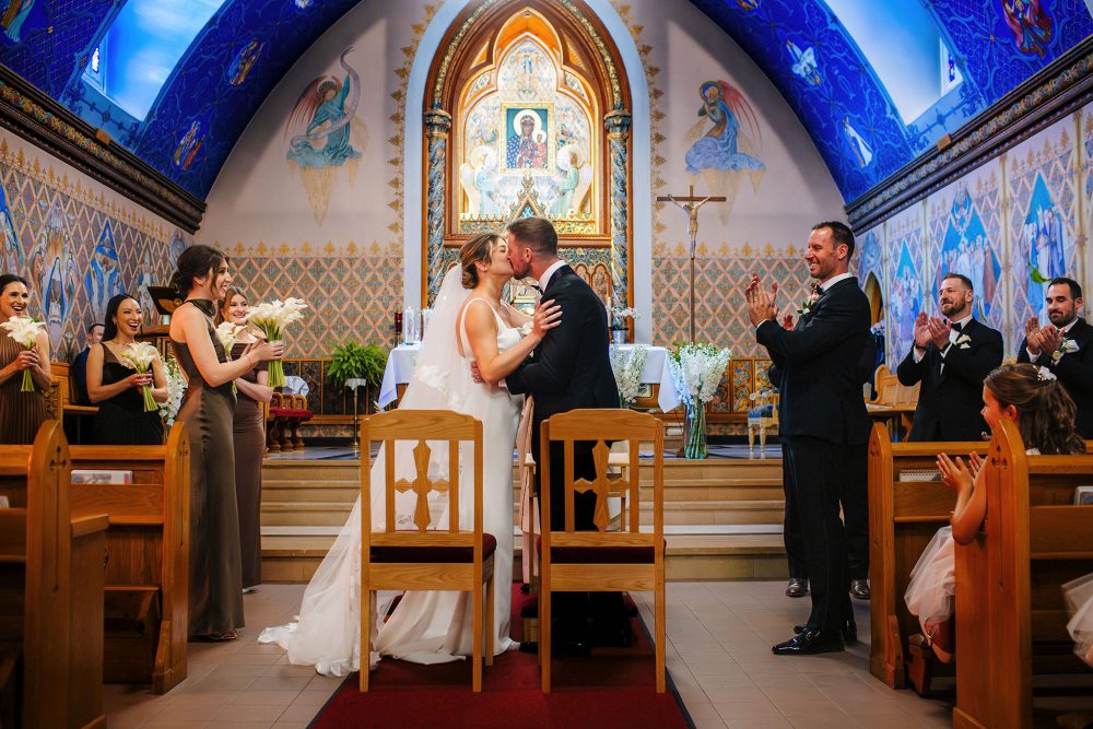 couple kiss at the front of an elaborate church